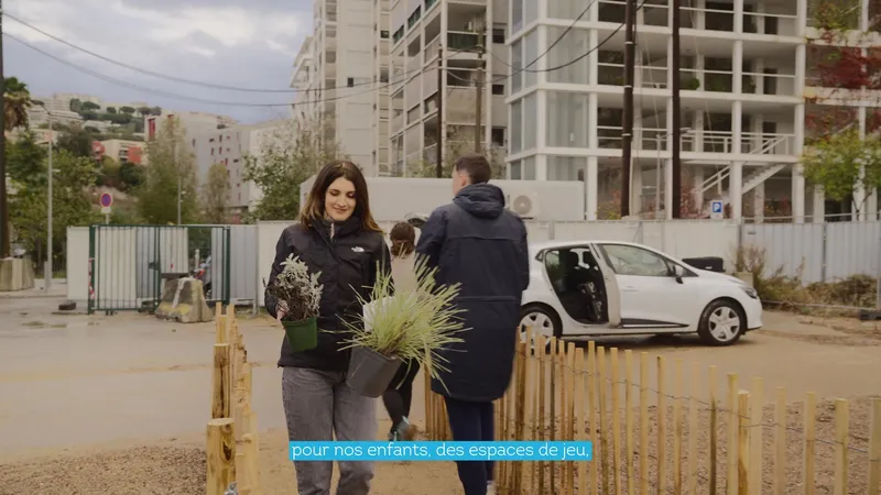 Des habitants plantent un arbre lors d'une concertation citoyenne de l'EPA Nice Écovallée, immeubles en construction en arrière-plan