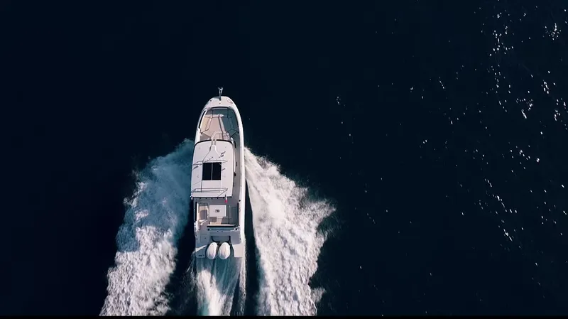 Aerial drone view of an Octo Boat vessel cutting through the Mediterranean, white wake on deep blue water