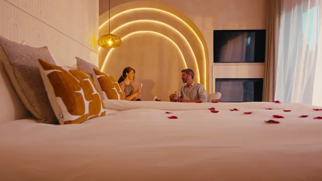 Bedroom at La Bastide des Rameaux with golden arches and rose petals on the bed